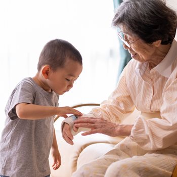 (Stock Image) Child examining grandmother's bandaged arm