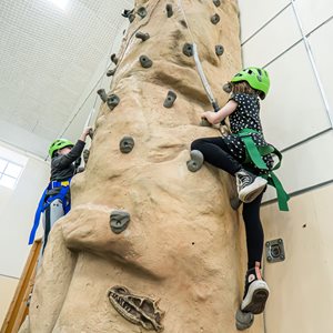 Image of kids on indoor climbing wall representing Pediatric Behavioral Day Treatment Adventure-Based Curriculum