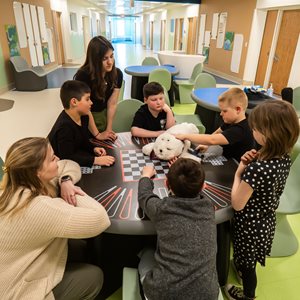 Image of kids engaging with robotic seal representing Pediatric Behavioral Day Treatment Interactive Group Therapy